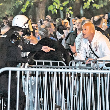 Полицајац настоји да умири демонстранта на недељним протестима у Подгорици (Фото: Ројтерс/Стево Васиљевић)