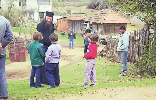 Пантелејмон дели помоћ српској деци у Лабљану код Приштине, 2002. (Фото: Милан Бојовић)